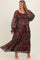 woman wearing a multi-colored paisley print maternity plus maxi dress with long sleeves and a cinched waist, showing a baby bump
