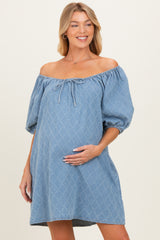 woman wearing a light blue off-the-shoulder maternity dress with puff sleeves and holding her baby bump