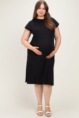 woman wearing a black short sleeve maternity dress with a relaxed fit, holding her baby bump