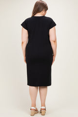 woman wearing a black maternity plus dress with cap sleeves and knee-length cut, showing the back view