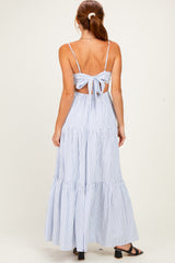 woman wearing a blue and white striped maxi dress with a back tie detail and tiered skirt