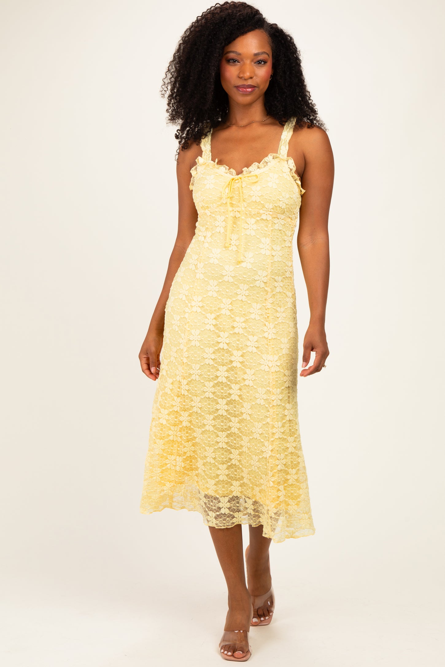 woman wearing a yellow lace midi dress with spaghetti straps and a tie-front detail