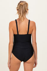 woman wearing a black maternity swimsuit with adjustable straps, view from the back