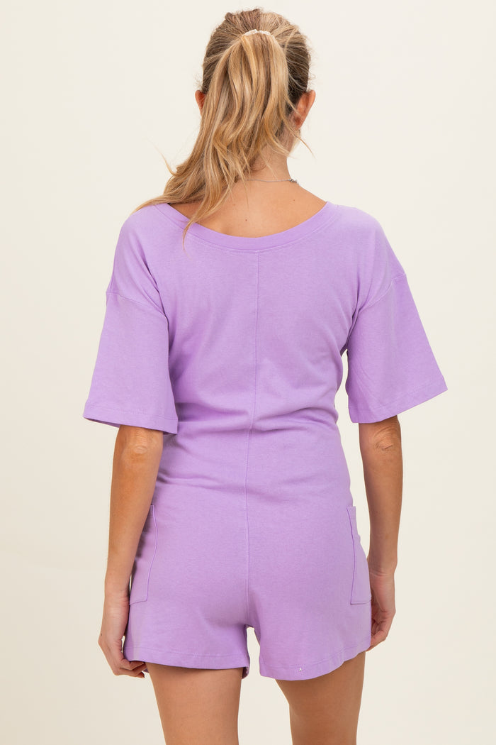 woman wearing a lavender short sleeve maternity romper with back pockets