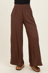 woman wearing brown wide-leg pants with a smocked waistband and side pockets
