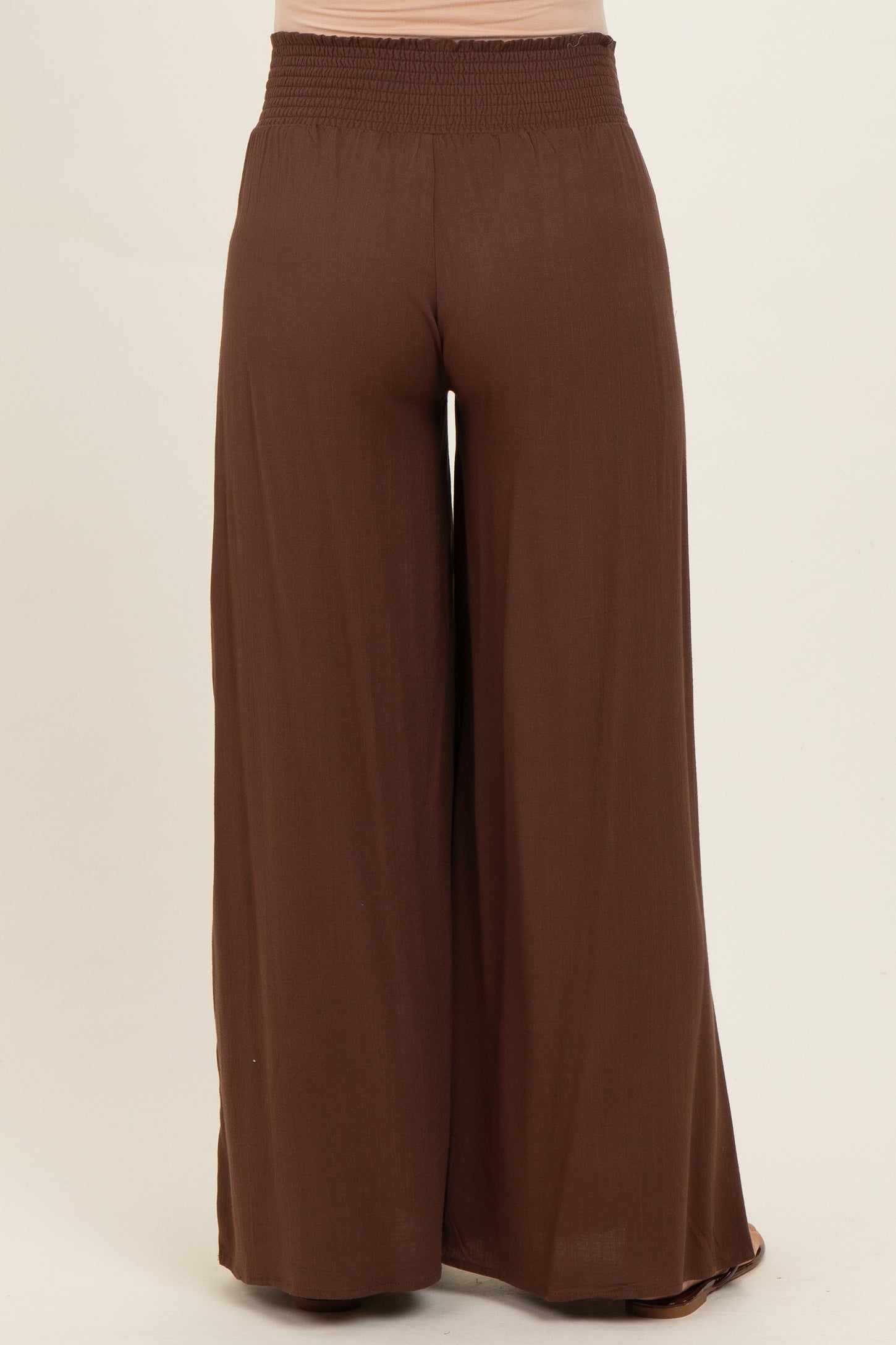 maternity wear in warm brown wide-leg pants with smocked waistband, shown from the back