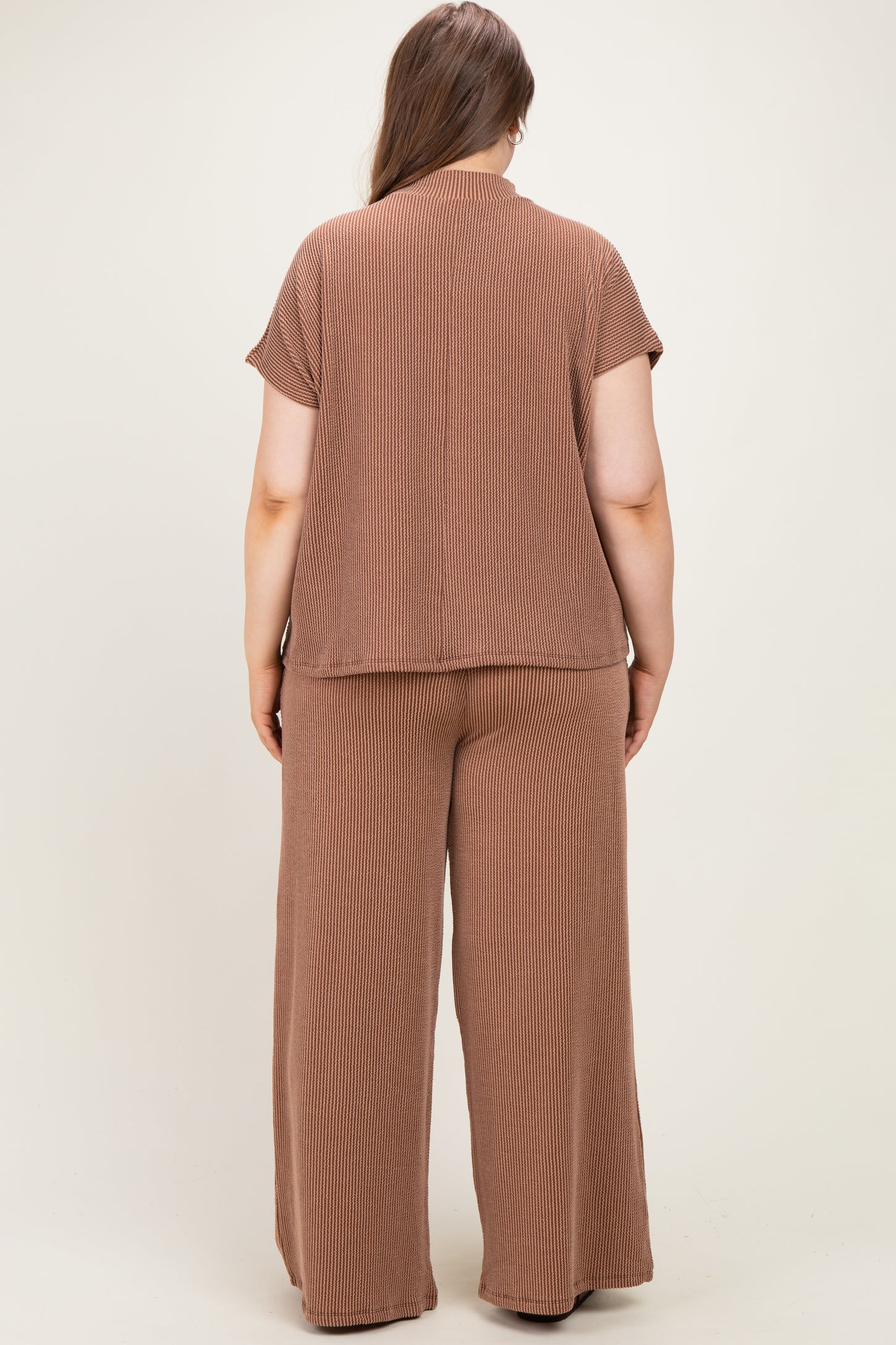 woman wearing a brown ribbed maternity plus lounge set, showing the back view of the top and wide-leg pants