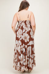 woman wearing a brown floral maternity maxi dress, showing the back view with adjustable straps and tiered skirt