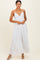 woman wearing a white maxi dress with thin straps and a flowing silhouette