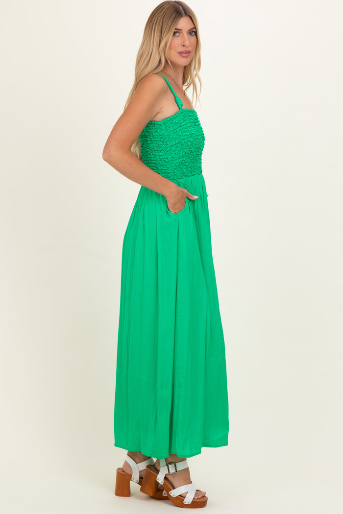 woman wearing a bright green maxi dress with a textured bodice and side pockets, paired with chunky heels