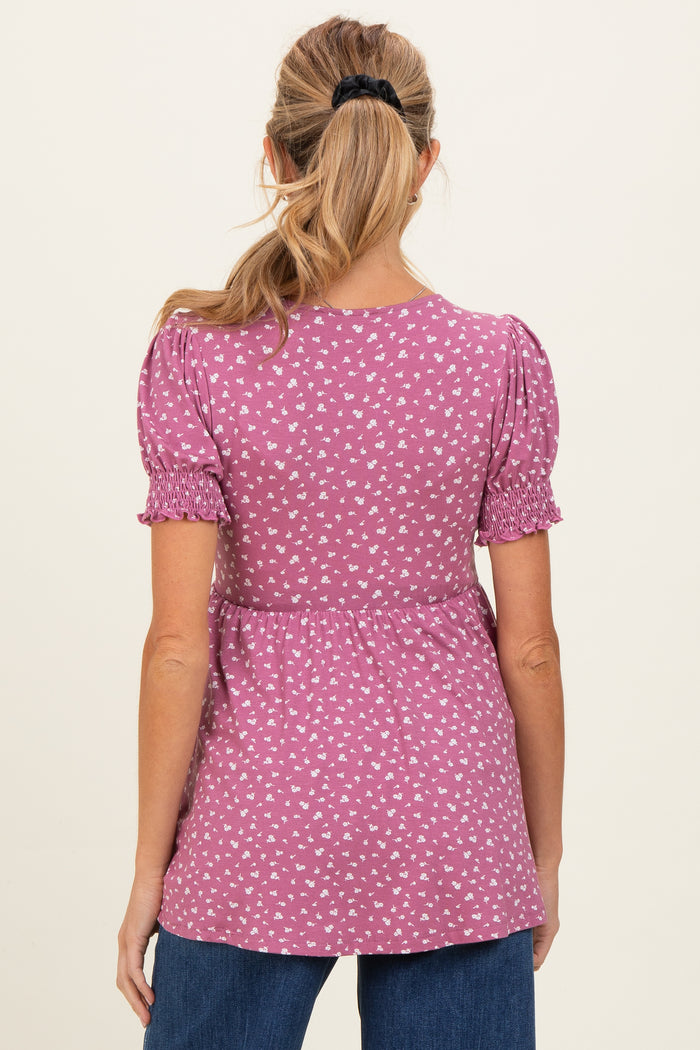 woman wearing a purple maternity top with puff sleeves and a floral print, showing a gathered seam at the waist