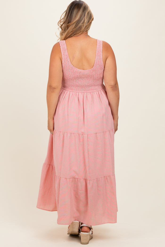woman wearing a pink tiered maternity maxi dress with a smocked bodice, showcasing her baby bump from the back