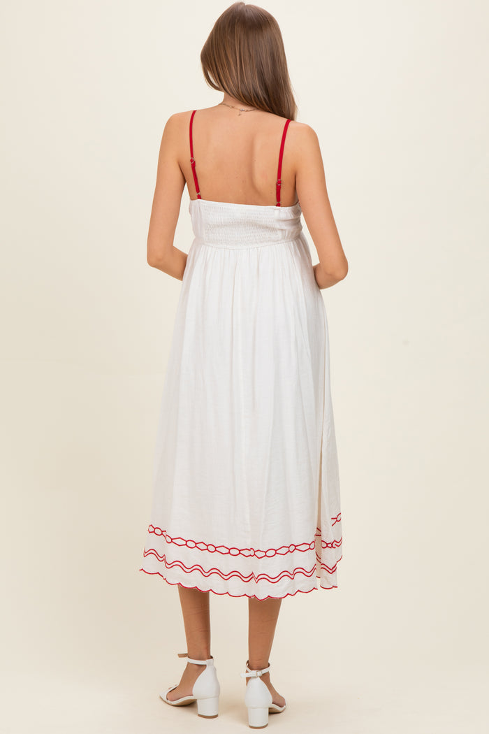 woman wearing a white maternity dress with red trim and adjustable straps, showing a baby bump from the back