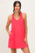 woman wearing a bright pink sleeveless dress with a v-neck and side pockets