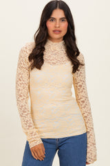 woman wearing a sheer yellow lace long sleeve top over a solid camisole with fitted styling and high neckline
