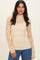 woman wearing a sheer yellow lace long sleeve top over a solid camisole with fitted styling and high neckline
