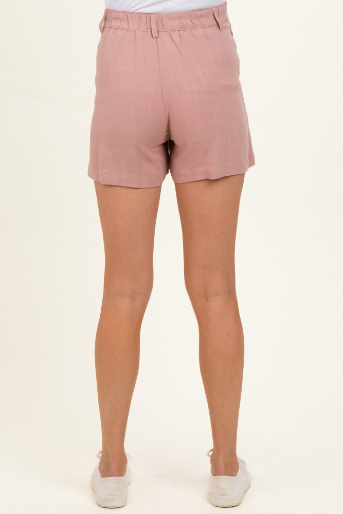 woman wearing light pink maternity shorts, shown from the back with a relaxed fit and elastic waistband