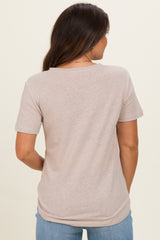woman wearing a light beige short sleeve maternity top, showing the back view with relaxed fit