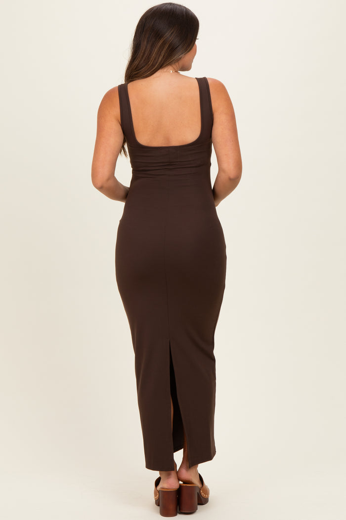 woman wearing a brown maternity maxi dress with a scoop back and side slit, showing her baby bump