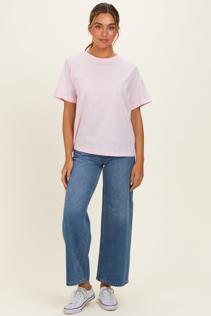 woman wearing a light pink short sleeve t-shirt and high-waisted wide-leg jeans with white sneakers
