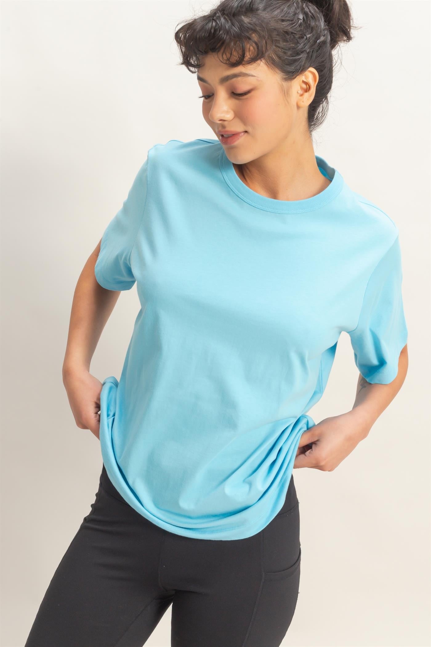 woman wearing a light blue short sleeve t-shirt and black leggings