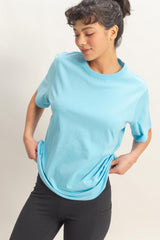woman wearing a light blue short sleeve t-shirt and black leggings