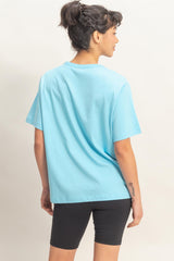 woman wearing a oversized light blue t-shirt and black bike shorts, viewed from the back