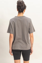 woman wearing a gray short sleeve shirt and black bike shorts, view from the back
