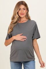 woman wearing a gray maternity short sleeve top and holding her baby bump