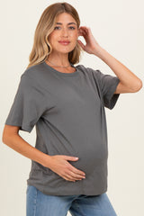 woman wearing a gray short sleeve maternity top and holding her baby bump