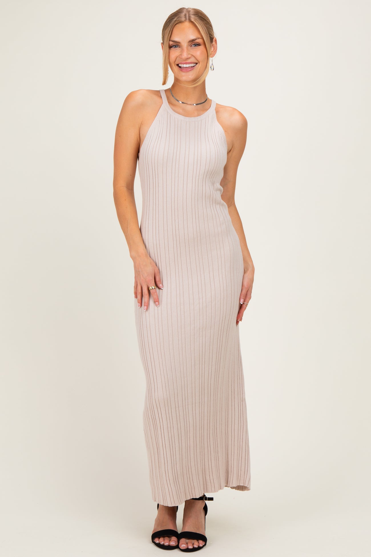 woman wearing a light beige ribbed maxi dress with a halter neck and spaghetti straps