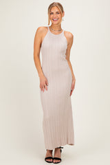 woman wearing a light beige ribbed maxi dress with a halter neck and spaghetti straps