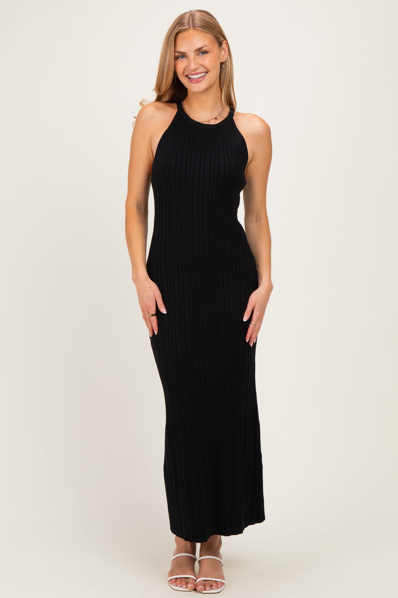 woman wearing a black ribbed maxi dress with a halter neck and a fitted silhouette