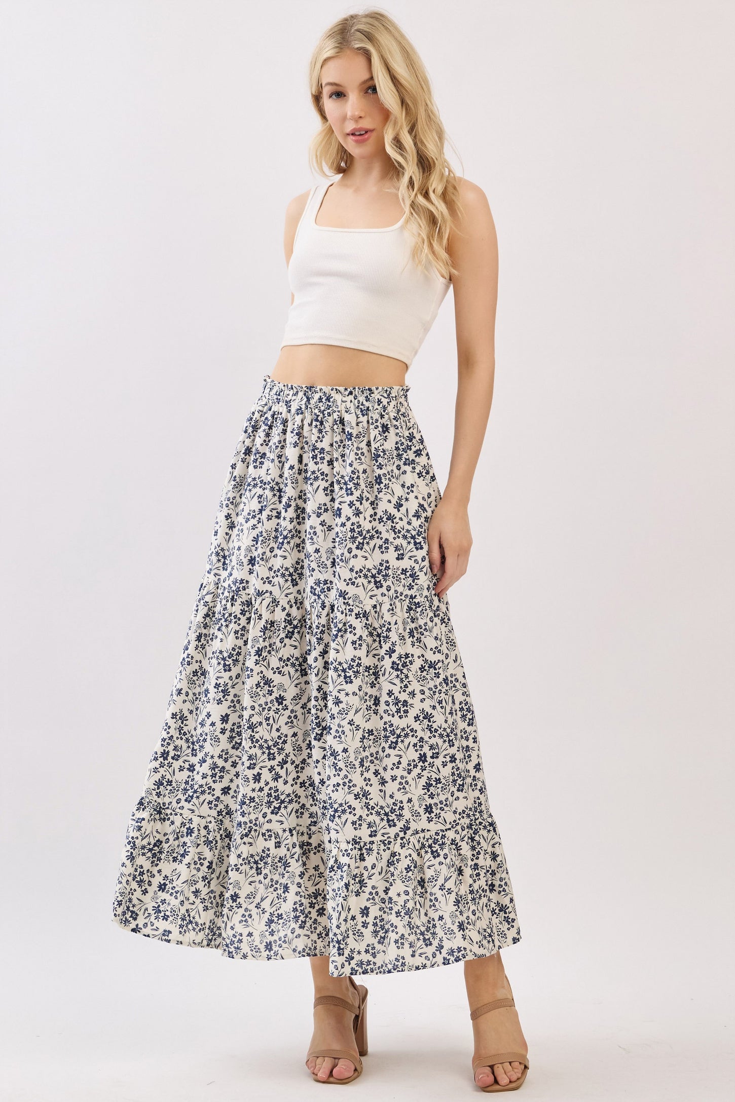woman wearing a white crop top and a long floral maxi skirt with blue patterns