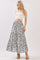 woman wearing a white crop top and a long floral maxi skirt with blue patterns
