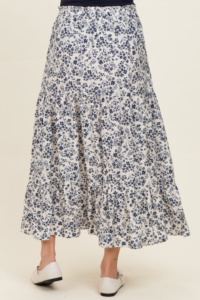 maternity wear tiered long floral skirt in white and navy with a flowy design, model shown from the back