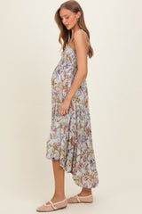 woman wearing a floral maternity maxi dress with a tiered hem and a visible baby bump