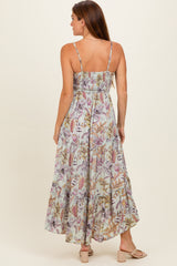 woman wearing a light floral maxi dress with spaghetti straps, showing a tiered skirt and gathered detail at the back