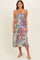 woman wearing a floral print midi dress with a smocked bodice and adjustable spaghetti straps