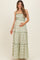 woman wearing a green and white floral print maternity maxi dress with a cinched waist and tiered skirt, holding her baby bump