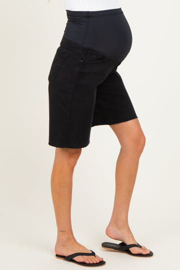woman wearing black maternity denim bermuda shorts, showcasing a visible baby bump