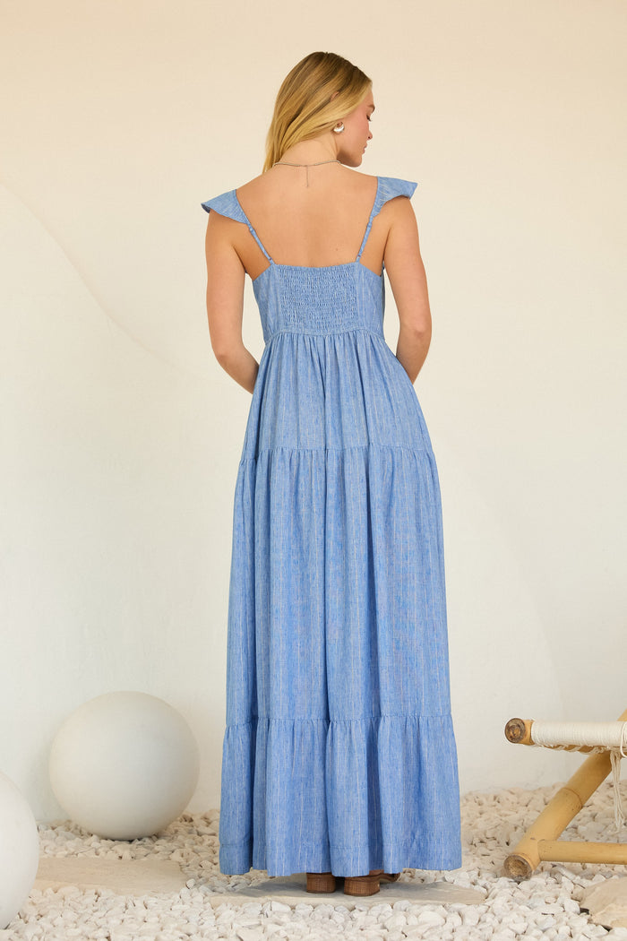 woman wearing a back view of a light blue tiered maxi dress with ruffled shoulder straps