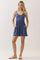 woman wearing a blue sleeveless romper with a fitted bodice and flared shorts, featuring side pockets