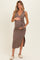 woman wearing a taupe maternity wrap dress with a tie waist and side slit, highlighting her baby bump