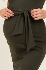 maternity wear dark green ribbed dress with a tie detail at the waist and a visible baby bump