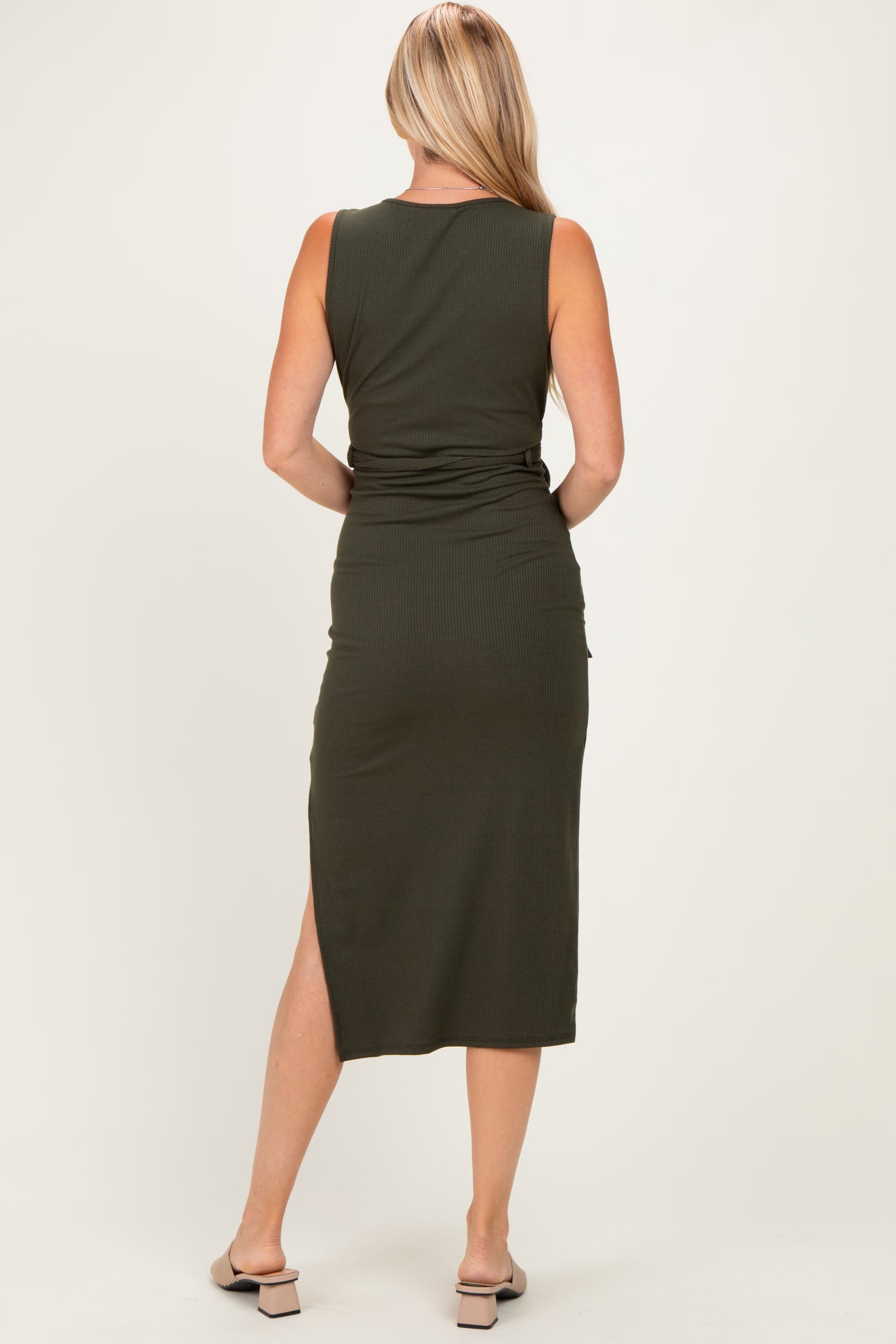 woman wearing a fitted olive green midi dress with a side slit and a sleek design, seen from the back