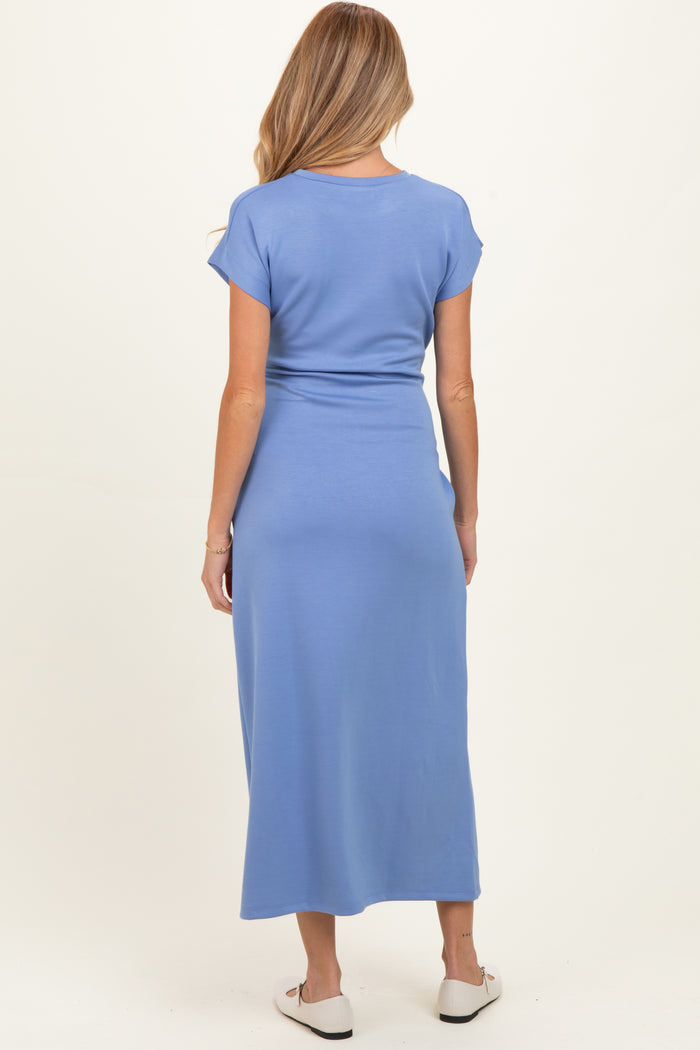 woman wearing a blue maternity maxi dress, shown from the back, featuring short sleeves and a fitted waist