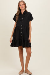 woman wearing a black short sleeve maternity dress with buttons and ruffle hem
