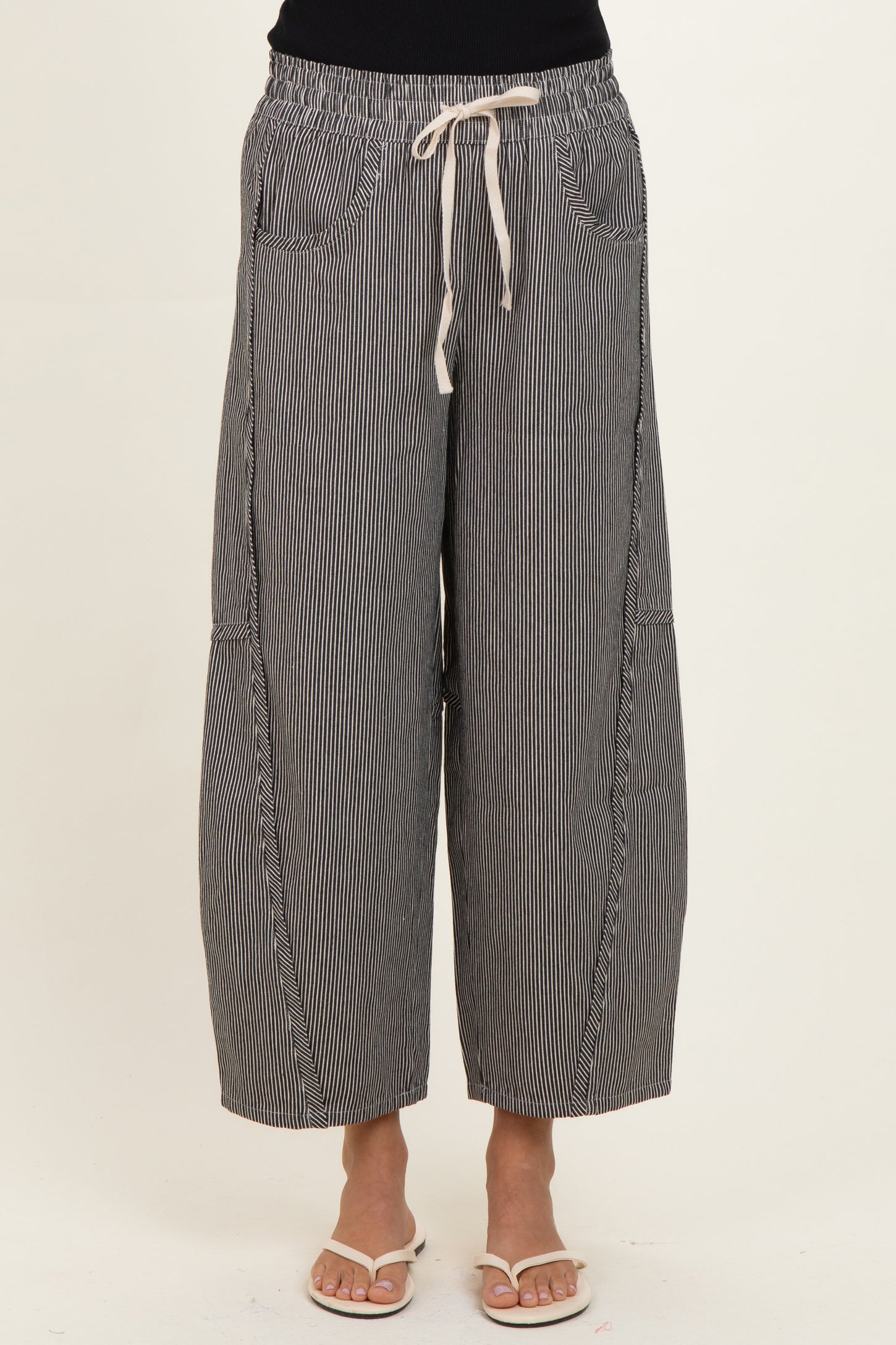 woman wearing black and white striped wide-leg pants with an elastic waistband and drawstring detail