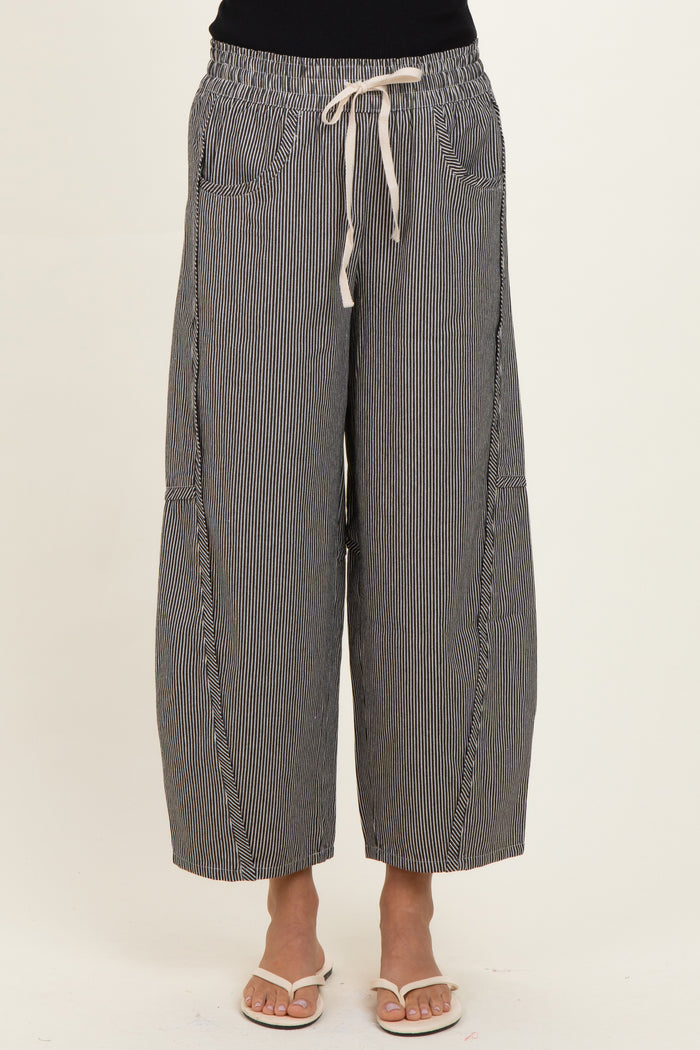 woman wearing black and white striped wide-leg pants with an elastic waistband and drawstring detail